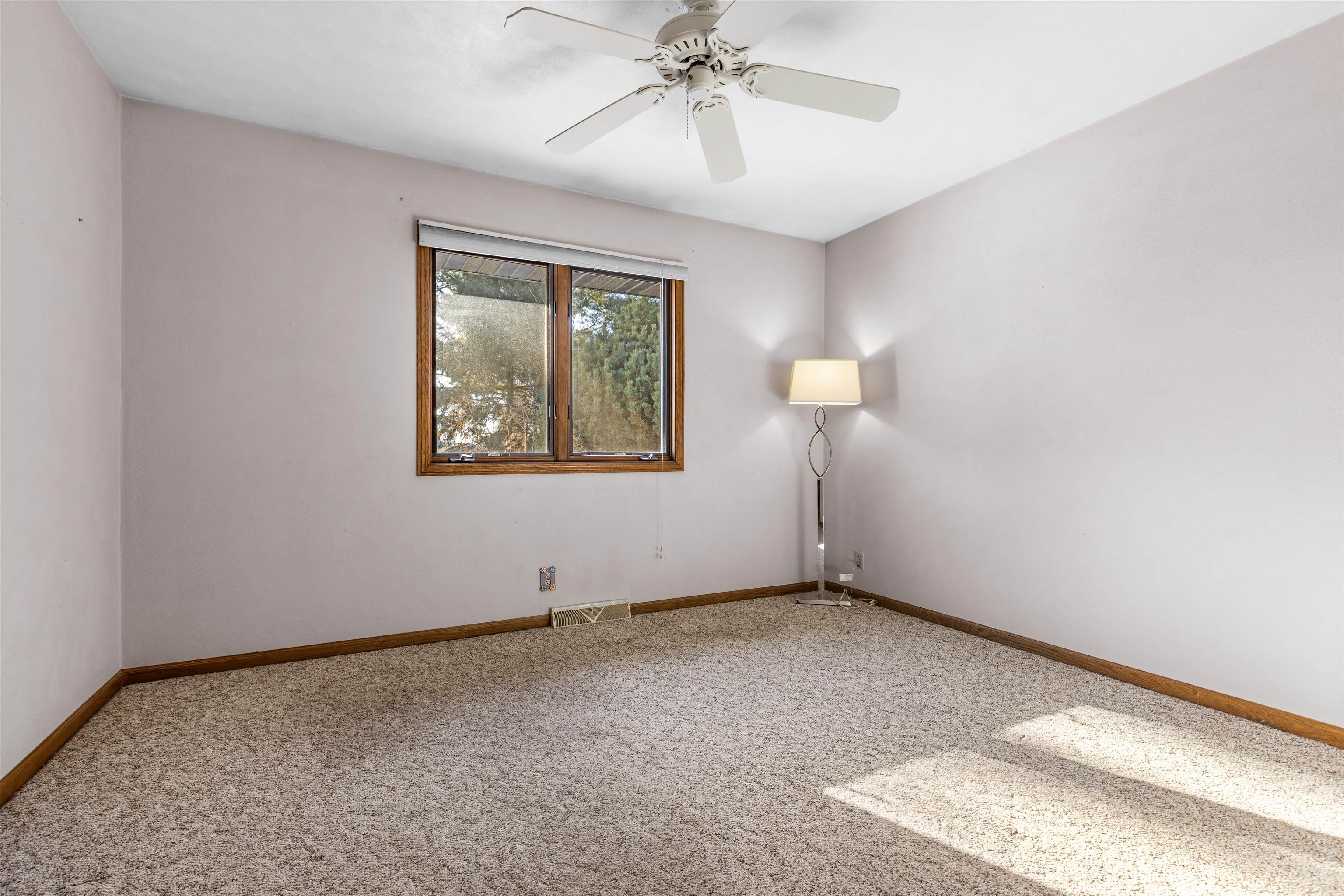 7467 McCurry Road Roscoe, IL 61073 - Photo 11 of 29 an empty room with a chandelier fan and windows