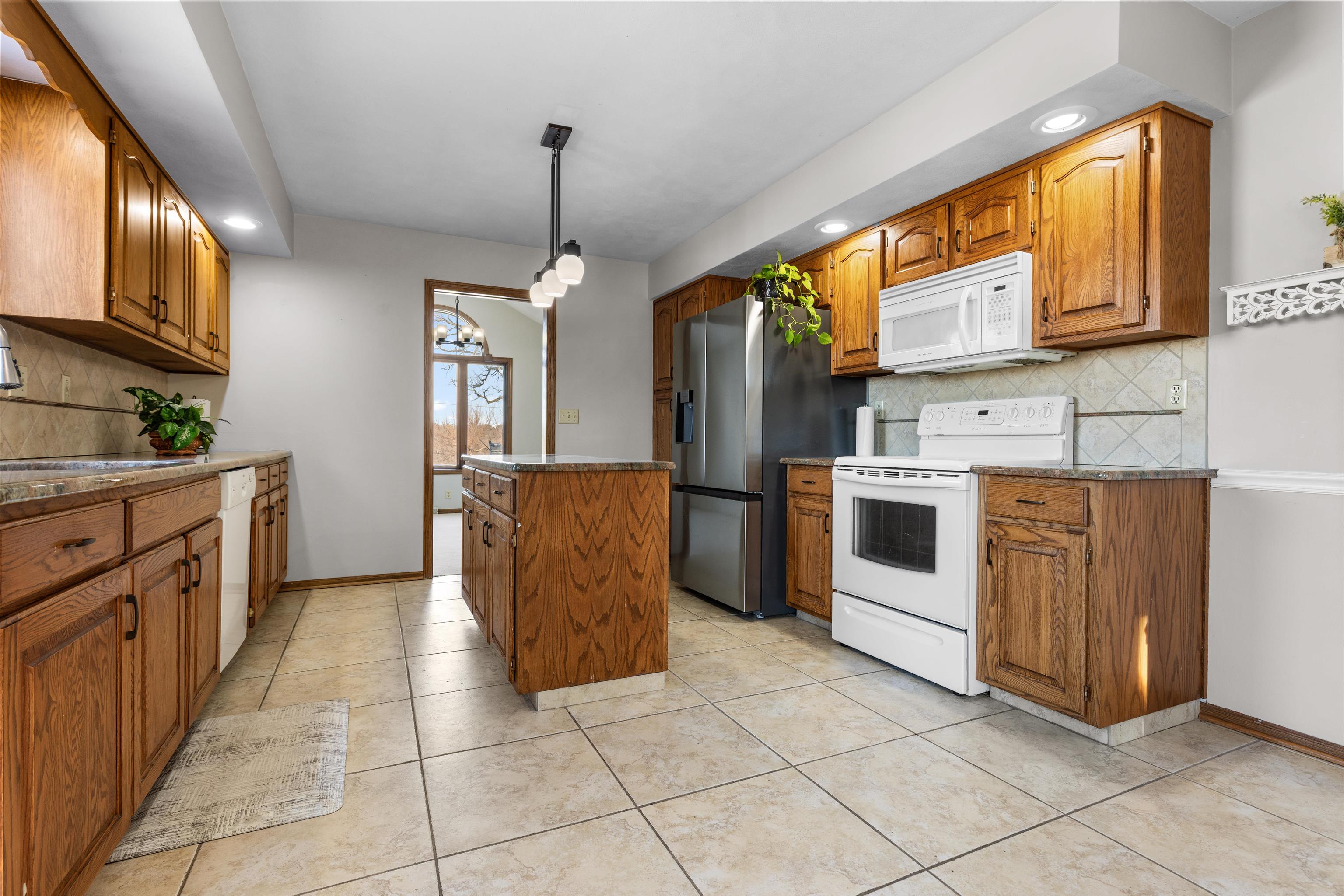 7467 McCurry Road Roscoe, IL 61073 - Photo 4 of 29 a kitchen with stainless steel appliances granite countertop a stove a sink and a refrigerator