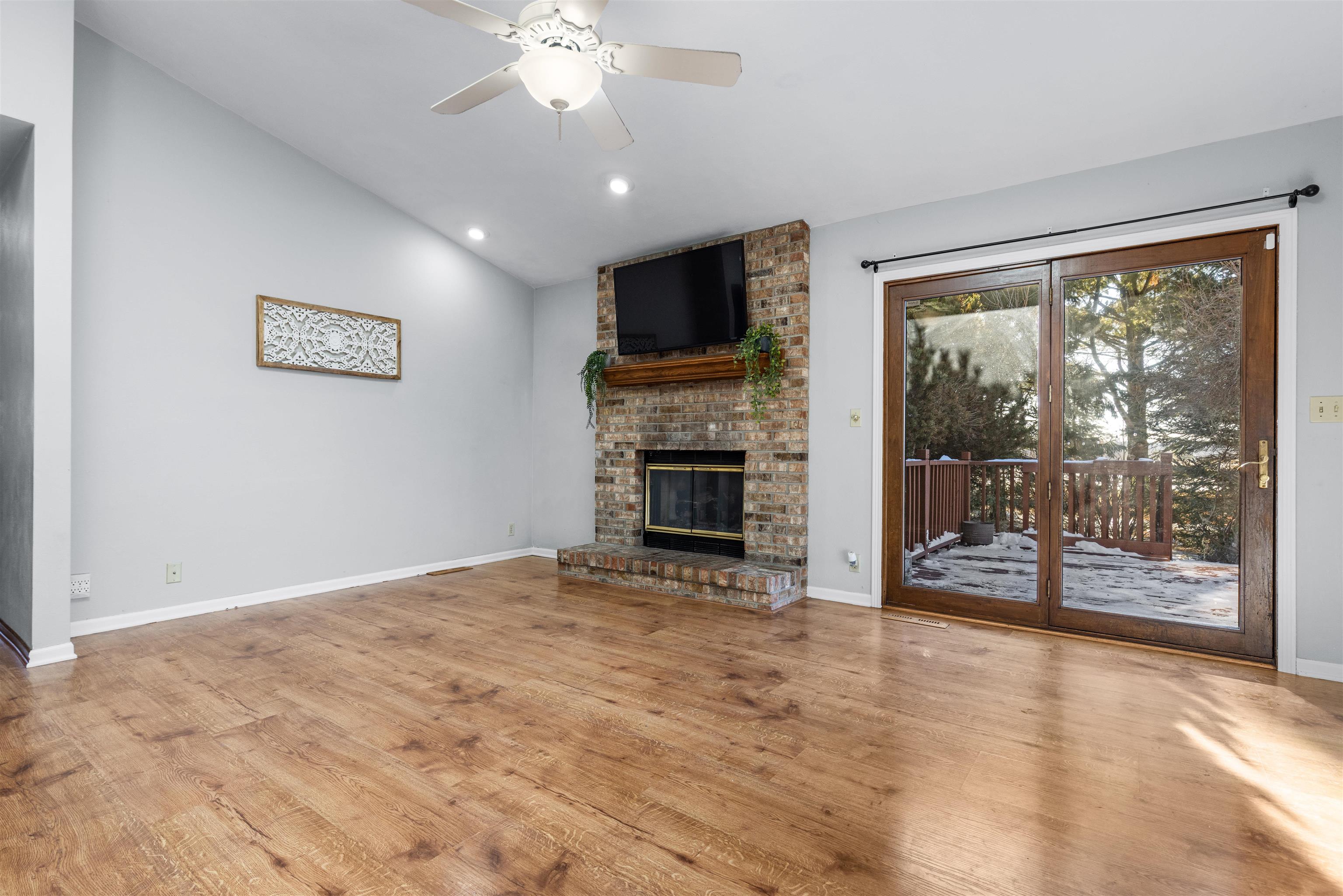 7467 McCurry Road Roscoe, IL 61073 - Photo 5 of 29 an empty room with fireplace wooden floor and windows