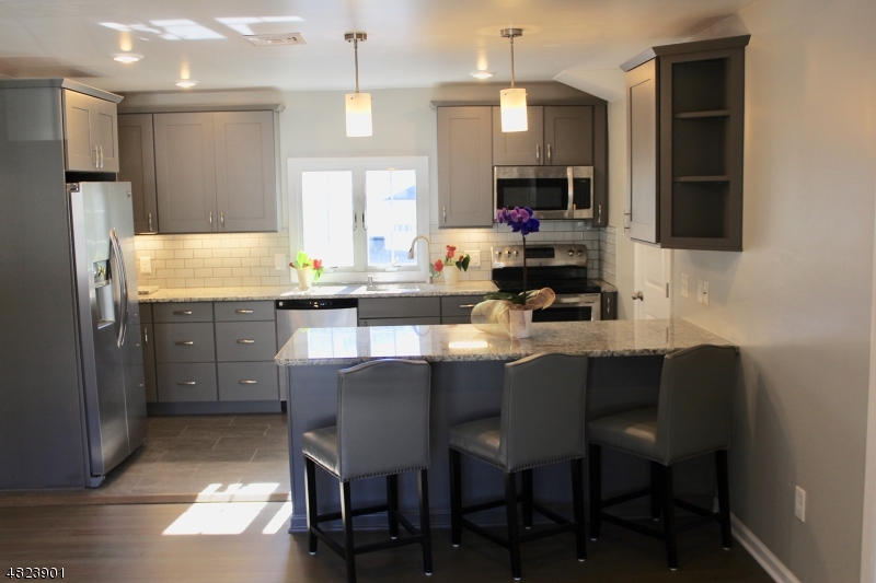 18 William Street, Unit 2 Summit, NJ 07901 - Photo 4 of 15 a kitchen with stainless steel appliances granite countertop a table chairs microwave and sink