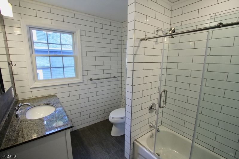18 William Street, Unit 2 Summit, NJ 07901 - Photo 7 of 15 a bathroom with a granite countertop sink toilet and shower