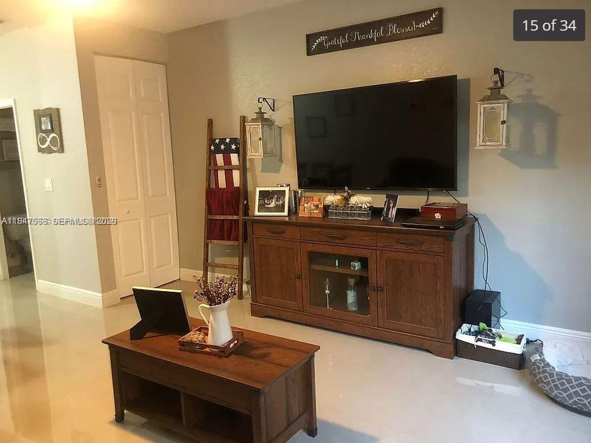 4913 Southwest 141st Avenue, Unit 2 Miramar, FL 33027 - Photo 4 of 12 a living room with a flat screen tv and a fireplace