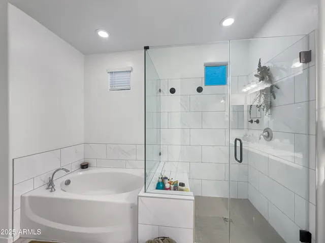 a spacious bathroom with a tub sink a shower a mirror and a bathtub