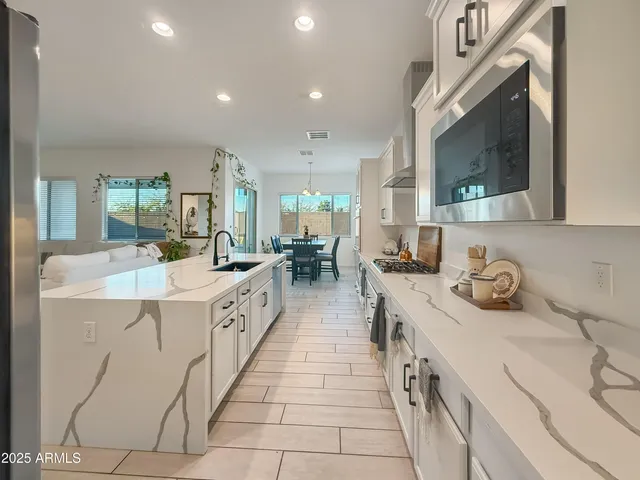 a large white kitchen with stainless steel appliances lots of counter top space