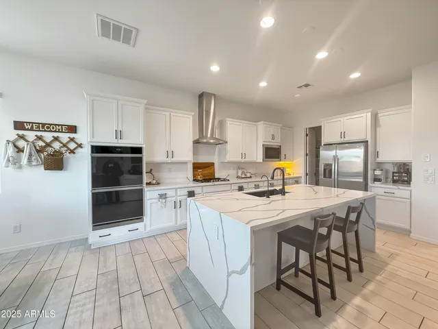 a kitchen with a sink a stove a refrigerator and white cabinets