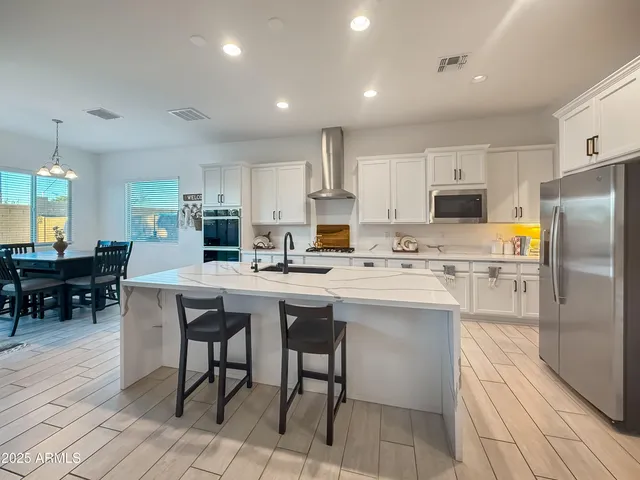 a kitchen with cabinets a sink stainless steel appliances and dining table
