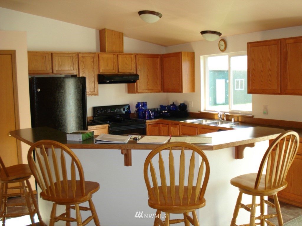 7325 187th Court Southwest Rochester, WA 98579 - Photo 4 of 9 a kitchen with stainless steel appliances a dining table chairs and a refrigerator