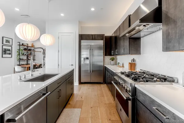 a kitchen with stainless steel appliances a stove a sink a refrigerator and a refrigerator