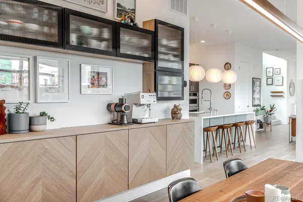 a kitchen with stainless steel appliances granite countertop a sink dishwasher a dining table and chairs with wooden floor