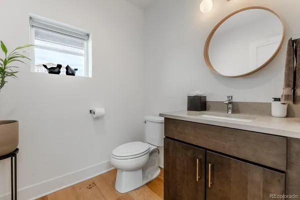 a bathroom with a toilet a sink and mirror