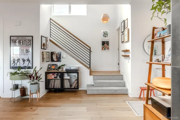 a view of staircase with lots of frames on wall and a dining table