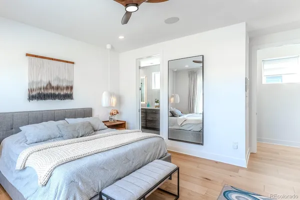 a bedroom with a large bed and wooden floor