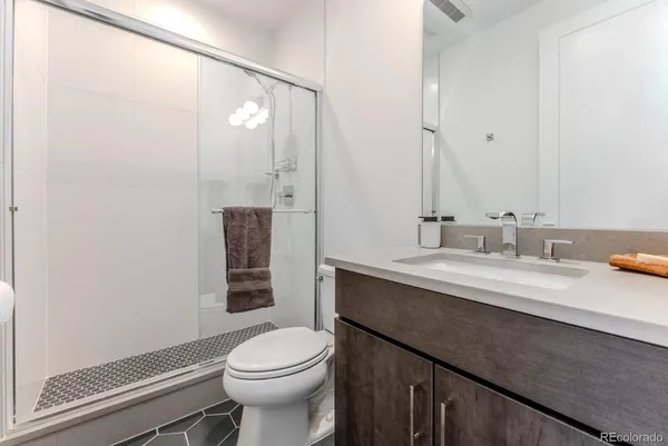 a bathroom with a granite countertop sink toilet and shower