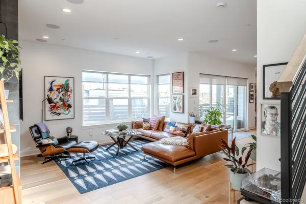 a living room with furniture flat screen tv and a large window