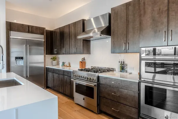 a kitchen with stainless steel appliances granite countertop a stove a sink and a refrigerator