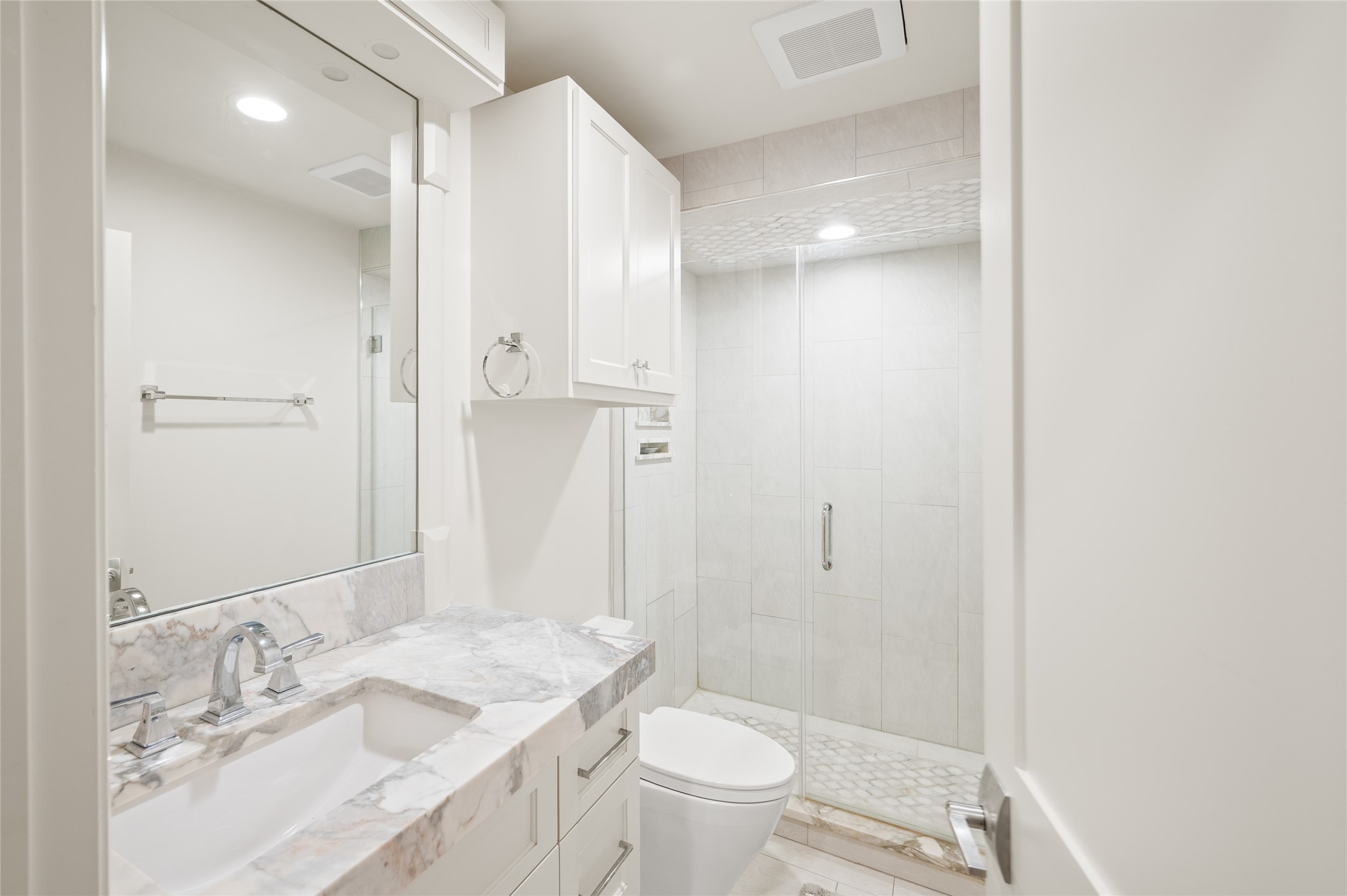 11518 Shadow Way Street Houston, TX 77024 - Photo 32 of 50 A well-appointed en-suite bathroom with marble countertops, storage cabinet, and a standing shower with beautiful tile flooring.