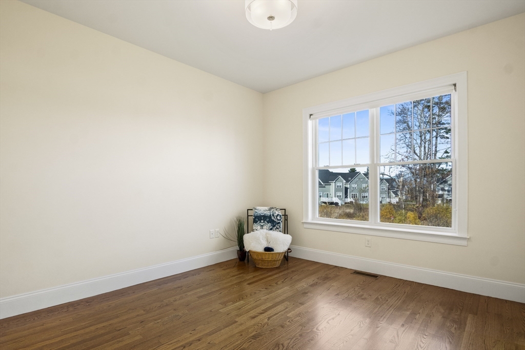 16 Winning Farm Road, Unit 16 Woburn, MA 01801 - Photo 14 of 42 a wooden floor in an empty room with a window