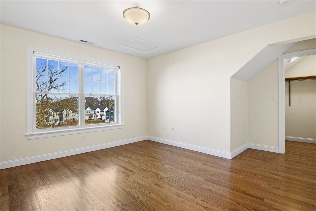 16 Winning Farm Road, Unit 16 Woburn, MA 01801 - Photo 17 of 42 a view of an empty room with wooden floor and a window