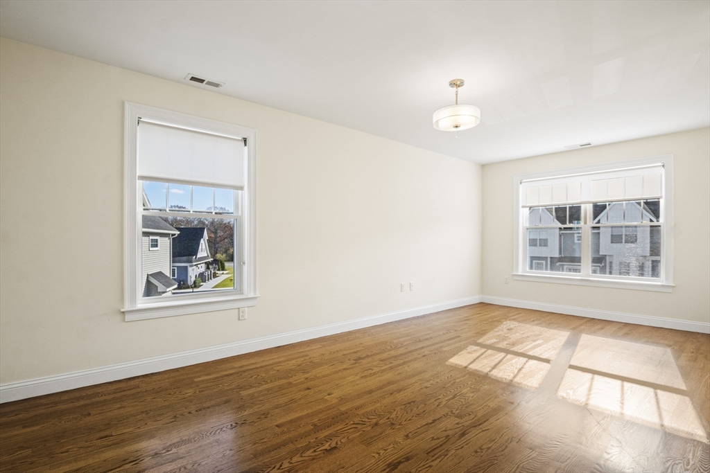 16 Winning Farm Road, Unit 16 Woburn, MA 01801 - Photo 21 of 42 a view of an empty room with wooden floor and a window