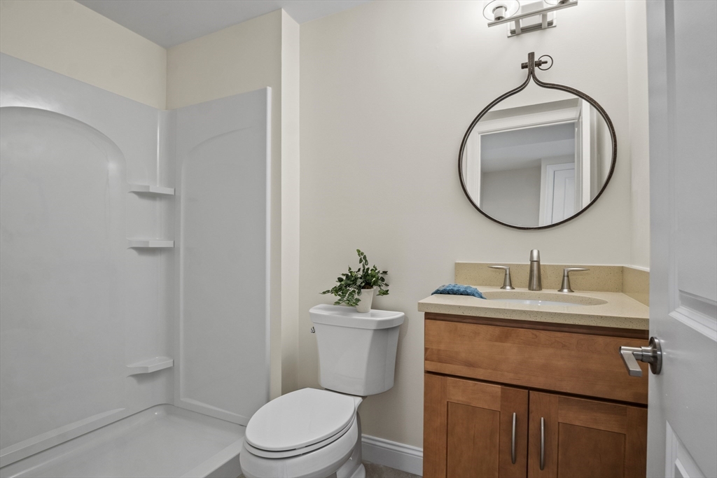 16 Winning Farm Road, Unit 16 Woburn, MA 01801 - Photo 30 of 42 a bathroom with a toilet sink vanity and mirror