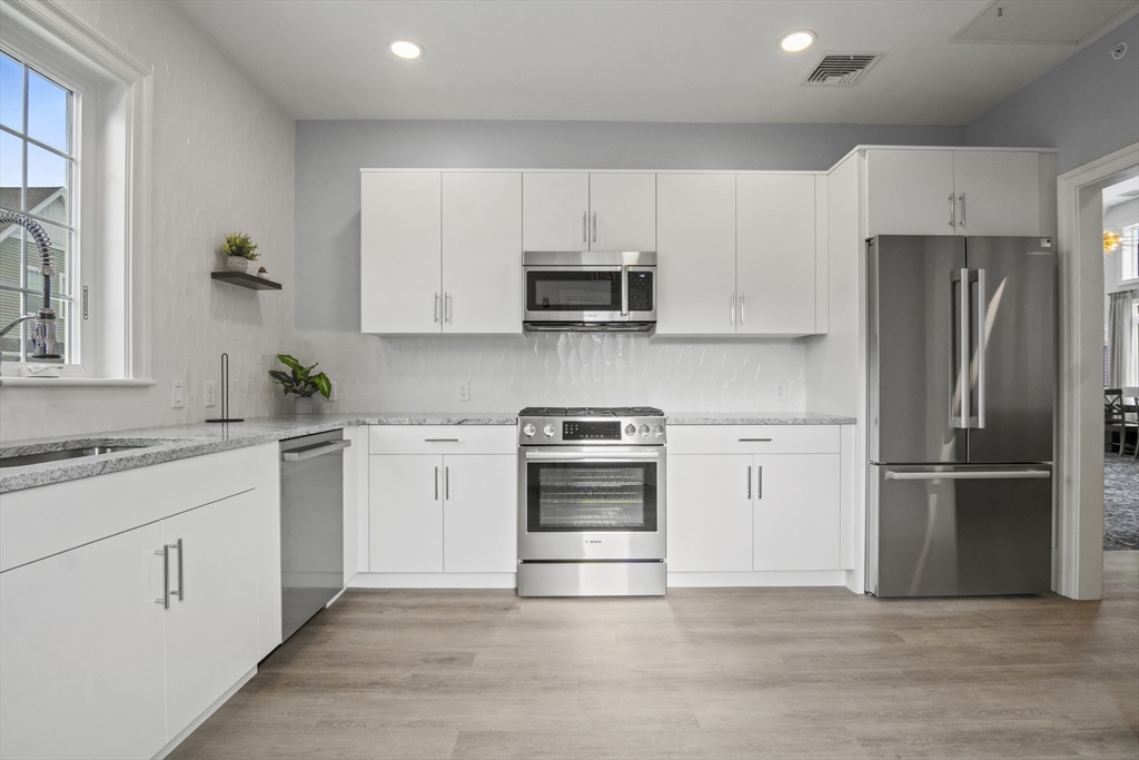 16 Winning Farm Road, Unit 16 Woburn, MA 01801 - Photo 39 of 42 a kitchen with cabinets stainless steel appliances and a window