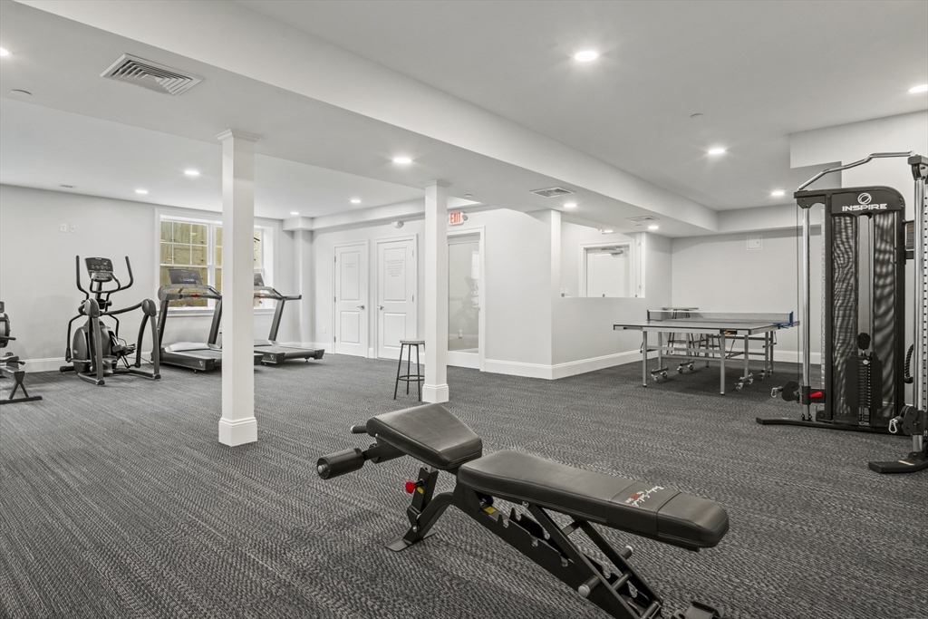 16 Winning Farm Road, Unit 16 Woburn, MA 01801 - Photo 40 of 42 a room with gym equipment and a table