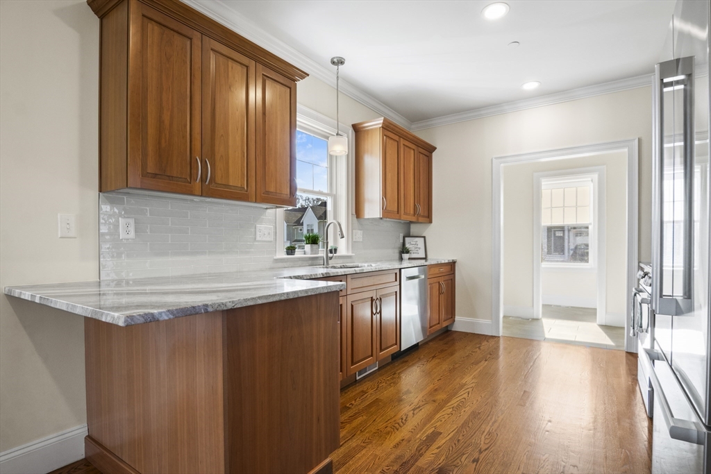16 Winning Farm Road, Unit 16 Woburn, MA 01801 - Photo 9 of 42 a kitchen with sink cabinets and wooden floor