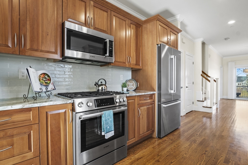 16 Winning Farm Road, Unit 16 Woburn, MA 01801 - Photo 10 of 42 a kitchen with stainless steel appliances granite countertop a stove a refrigerator and a microwave