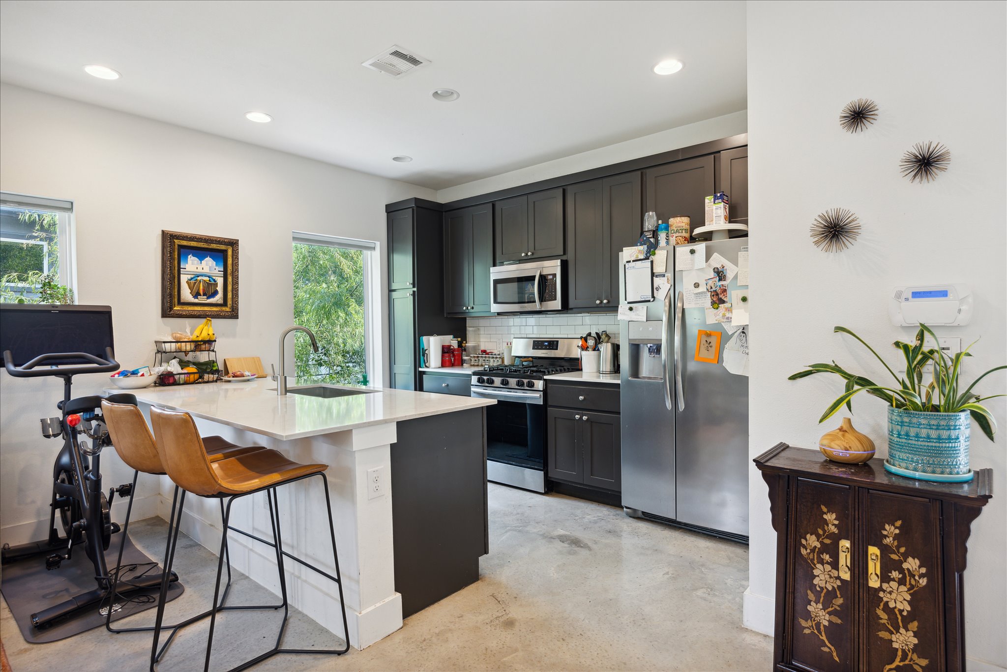 5006 Baker Street, Unit B Austin, TX 78721 - Photo 7 of 16 a kitchen with stainless steel appliances granite countertop a refrigerator a stove a sink dishwasher and a dining table with wooden floor