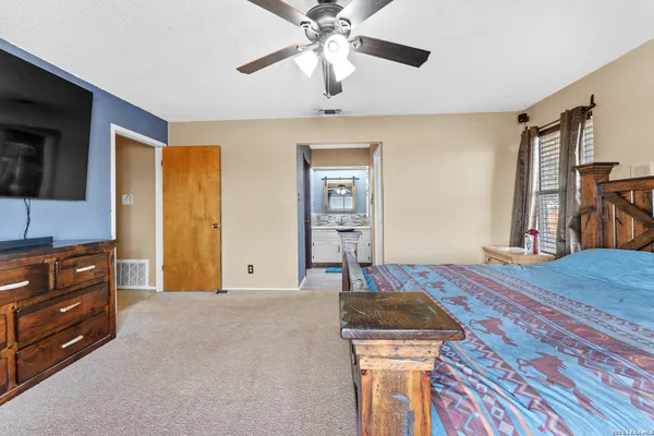 a bedroom with a bed and a flat tv screen on dresser