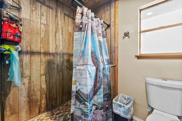 a bathroom with a toilet and a shower curtain