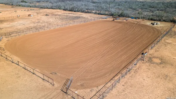 a view of a dry yard with wooden fence
