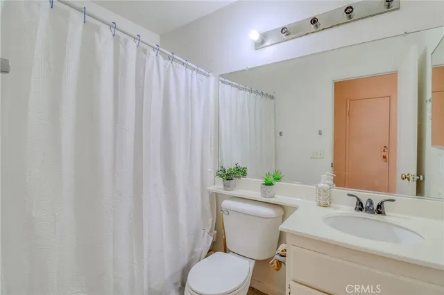 a bathroom with a toilet a sink and curtain