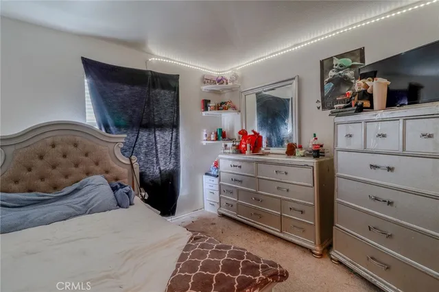 a bedroom with a bed and a flat tv screen in it