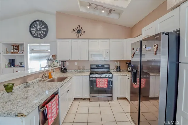 a kitchen with a refrigerator a sink and cabinets