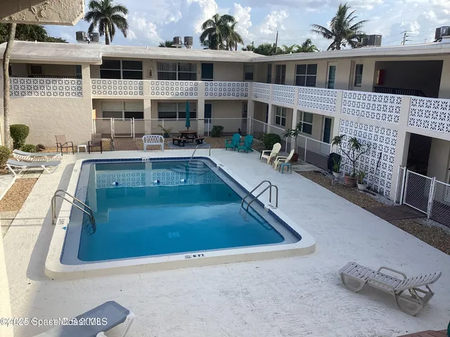 a view of a house with pool fire pit and chairs