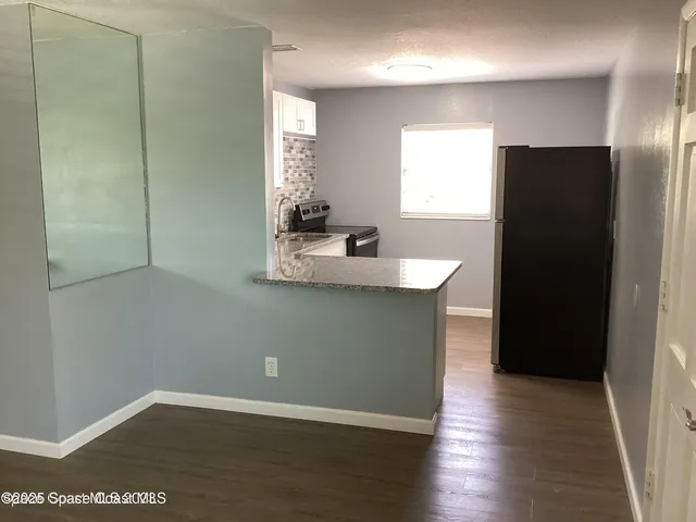 a kitchen with granite countertop a refrigerator and a sink