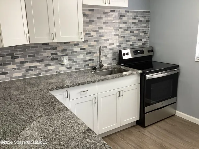 a kitchen with stainless steel appliances granite countertop a stove sink and cabinets