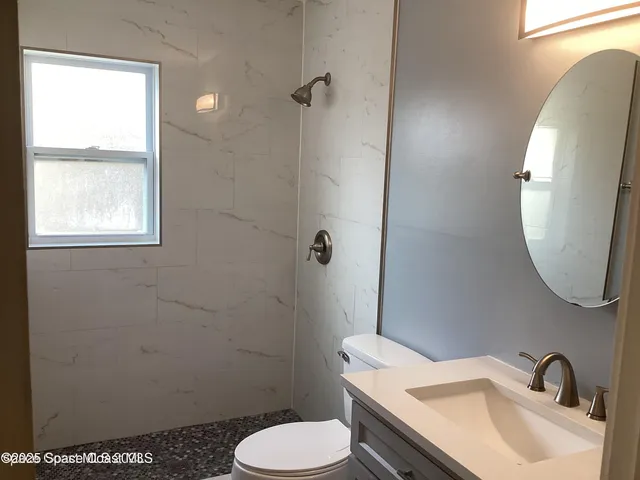 a bathroom with a sink toilet and a mirror