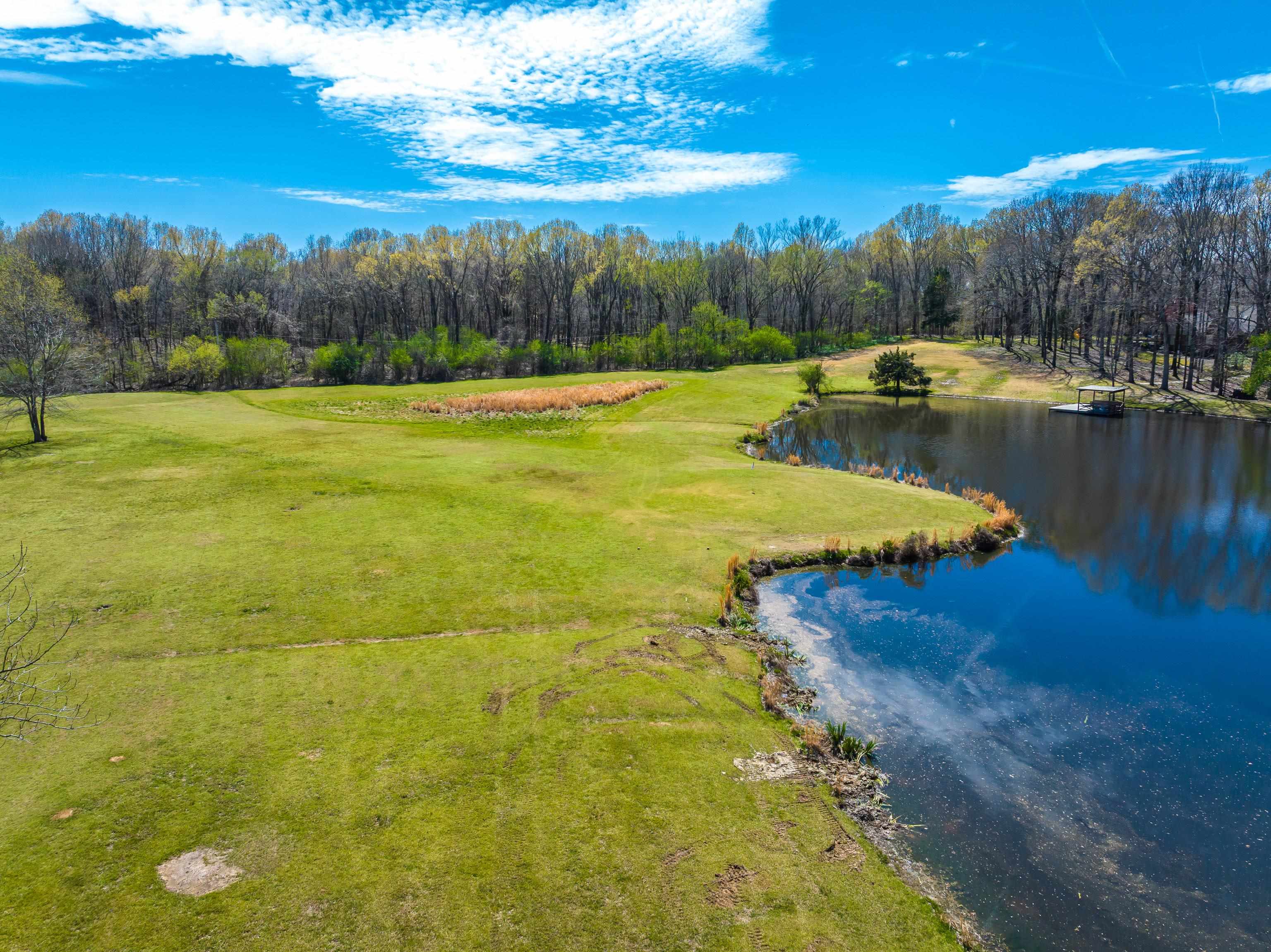 9155 Rocky Cannon Road Memphis, TN 38018 - Photo 15 of 20 a view of a lake with a yard and trees