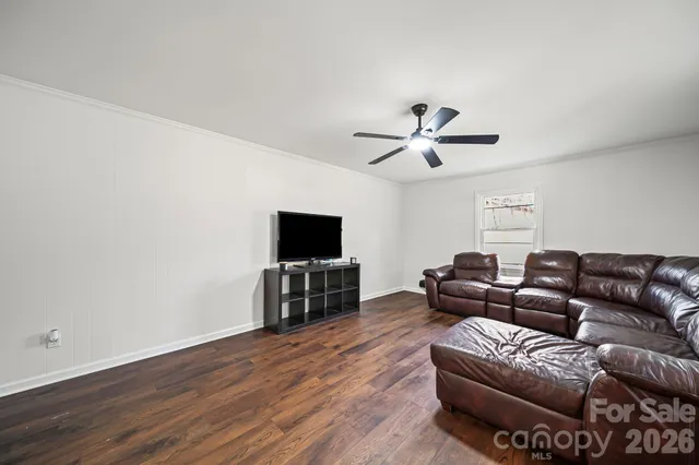 a living room with furniture and a flat screen tv with wooden floor