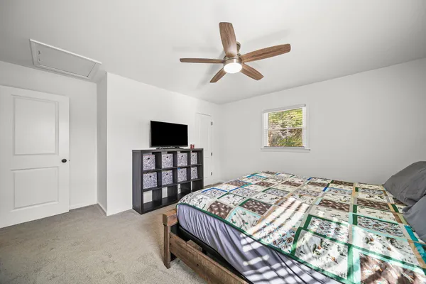 a bedroom with a bed and a flat screen tv