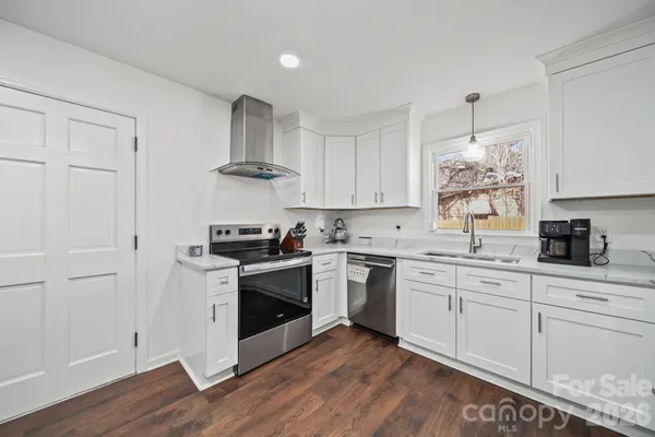 a kitchen with cabinets stainless steel appliances and a window