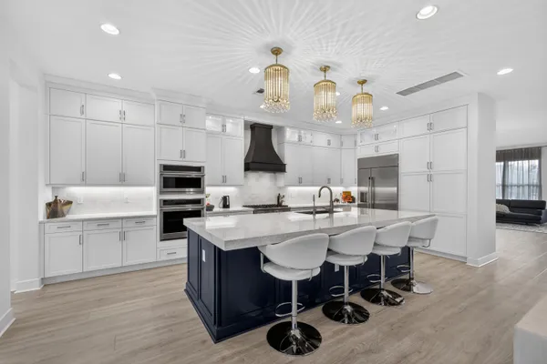 a kitchen with a sink a stove a dining table and chairs