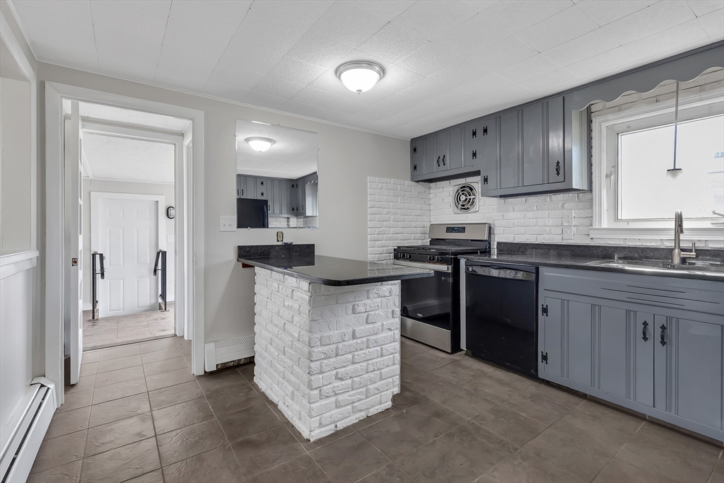 242 Welcome Street Fall River, MA 02721 - Photo 7 of 21 a kitchen with stainless steel appliances kitchen island granite countertop a stove a sink and a refrigerator