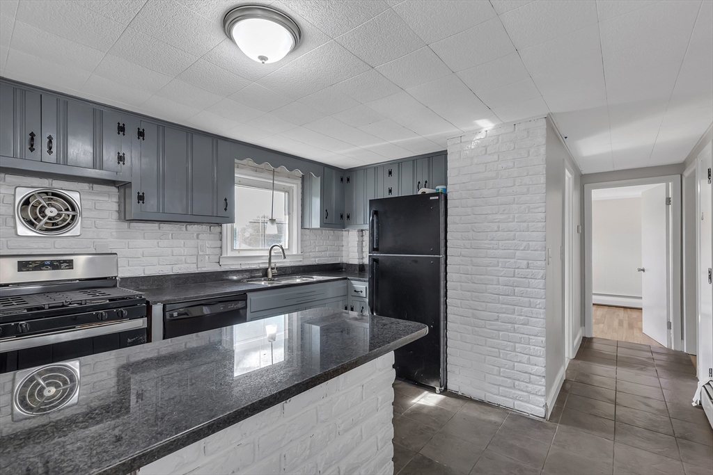 242 Welcome Street Fall River, MA 02721 - Photo 8 of 21 a kitchen with granite countertop stainless steel appliances and wooden cabinets