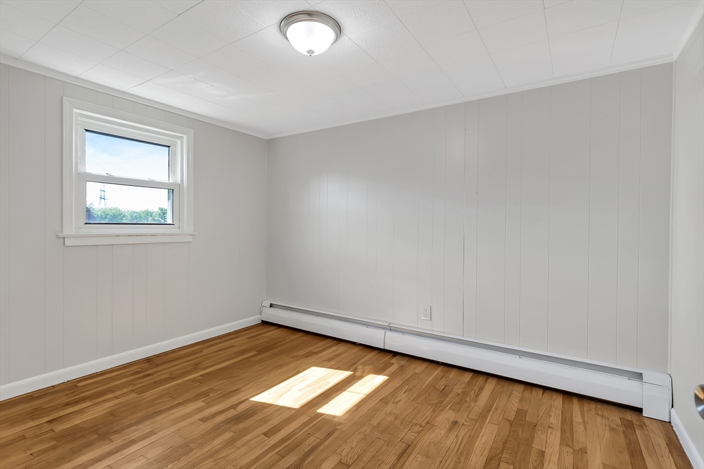 242 Welcome Street Fall River, MA 02721 - Photo 10 of 21 wooden floor in an empty room with a window