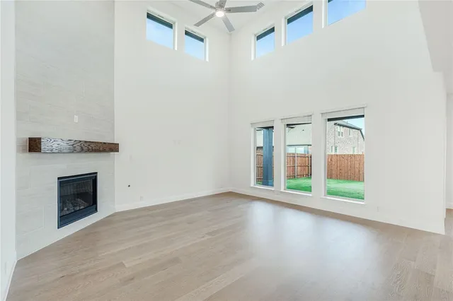 an empty room with windows and fireplace