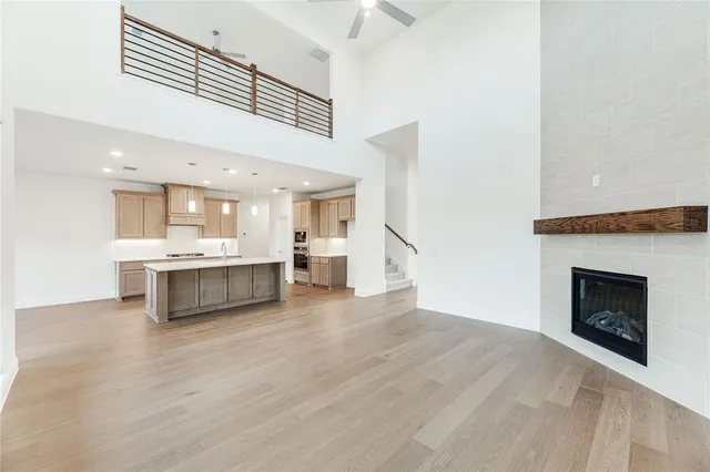 a large white kitchen with kitchen island a sink stainless steel appliances and cabinets