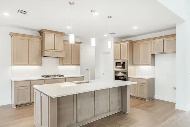 a kitchen with kitchen island white cabinets and stainless steel appliances